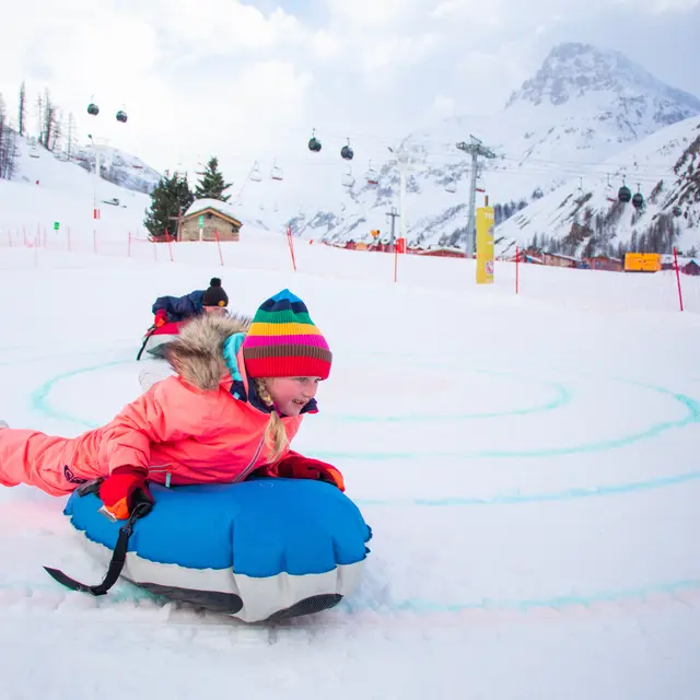 Curling humain en famille à Val d'Isère en hiver sur la piste de la Savonnette