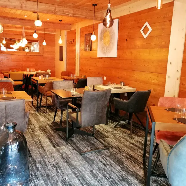 Salle intérieure du restaurant, tables et chaises, ambiance lumineuse et confortable