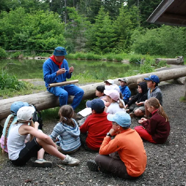 Médiateur devant un groupe d'élèves à côté du lac de Fuzet