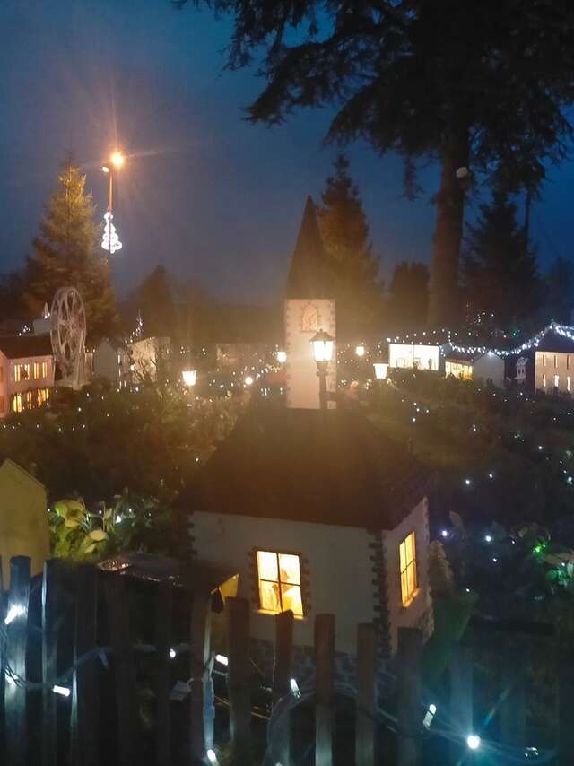 Village miniature illuminé, marché de Noël et concert
